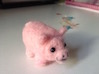 The front of a needle-felted pink pig that appears to be smiling.